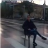 На оживлённой улице Красноярска парень уселся на стул посреди пешеходного перехода (видео)